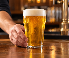 A freshly poured golden beer with a neat foam head